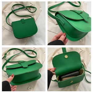 Detail view of a bright green leather saddle bag showing interior space and fine texture