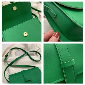 Detail view of green shoulder bag showing magnetic closure and stitching details