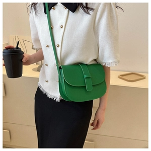 Vibrant green crossbody flap bag worn on model showing size and styling in bright room