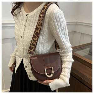 Brown leather saddle bag for women with jacquard strap and gold U-shaped buckle decoration