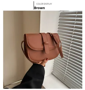 Detailed close-up of a vintage tan saddle bag with matte finish and decorative buckle