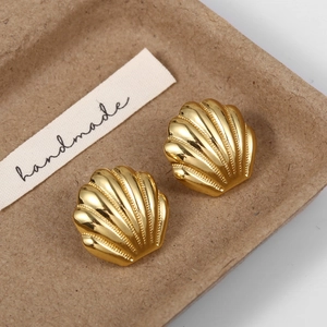 Macro dei dettagli degli orecchini a conchiglia placcati in oro 18K con texture