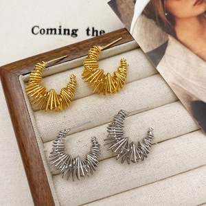 French vintage gold and silver irregular twisted hoop earrings on a beige display tray