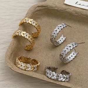 Gouden en zilveren ringen en oorbellen met bladmotief en zirkoon in een lade