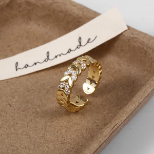 Macro-opname van bladvormige open ring met gouden afwerking en micro-zirkonen