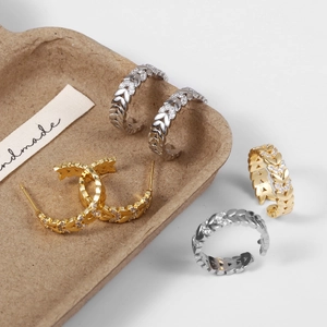 Detail van de zirkonia blad oorbellen en verstelbare ring in goud en zilver afwerking