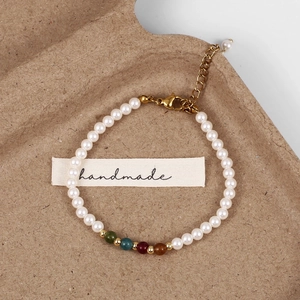 Detail of handmade pearl bracelet with colorful stones and a gold lobster clasp