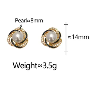 Elegant gold pearl stud earrings with black enamel swirl and micro-set diamonds