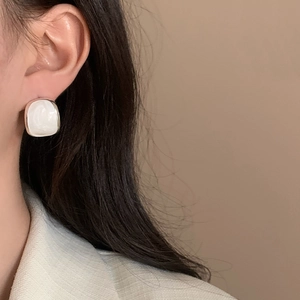 Elegant french vintage oval silver stud earrings with white enamel on a model