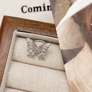 Macro detail of silver butterfly ring with cubic zirconia in a premium wooden jewelry box