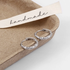 Detailed shot of twisted silver hoop earrings with pavé set cubic zirconia accents
