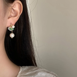 Eleganti orecchini a goccia con perla e camelia indossati da una modella
