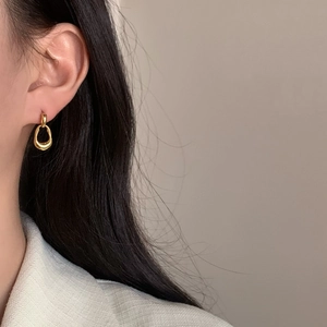 Minimalist gold irregular hoop earrings with organic streamlined design on female model