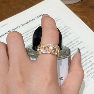 Gold Cuban link chain ring featuring rectangular clear zircons on a model's finger