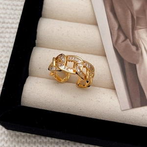 Adjustable gold chain ring with hollow links and zircon stones on a velvet display