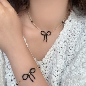 Set vintage collana e bracciale a farfalla con perline nere su maglione bianco chic