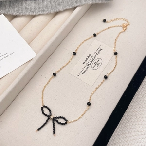 Collana a catena dorata vintage con perle nere e delicato ciondolo a farfalla