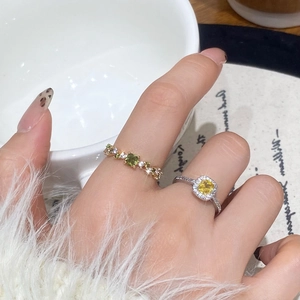 Elegant gold and silver zirconia rings shown on hand in a French tea setting