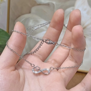 Collier cœur infini argenté avec cristaux scintillants sur une chaîne délicate