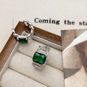 Elegant silver curb chain hoop earrings with square emerald green zircon stones in a jewelry box
