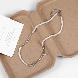 Detail of pearl necklace with irregular silver branch-shaped metal on pulp packaging