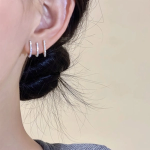 Elegant three-row micro-set zircon hoop earrings in silver on model's ear