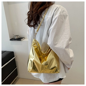 Detail of a metallic gold hobo bag with high-shine finish and golden chain shoulder strap