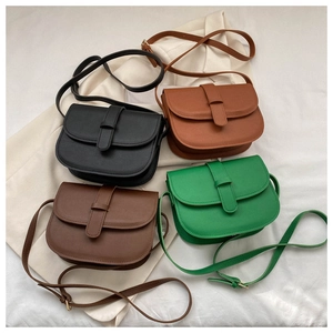 Modern saddle bags in four colors displayed on beige fabric and a matching blazer