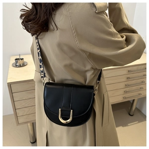 Chic black semi-circular saddle crossbody bag with golden buckle and textured strap