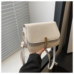 Détail du sac bandoulière en cuir crème avec fermoir en métal doré et sangle réglable