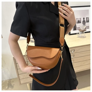 Sacoche selle en cuir marron avec bandoulières amovibles portée par un mannequin