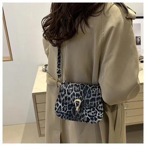 Vue latérale d'un sac bandoulière léopard avec boucle dorée porté par un mannequin