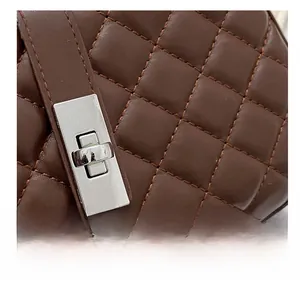 Gros plan du sac en cuir matelassé marron avec fermoir tournant rectangulaire en métal argenté