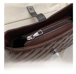 Détail d'un sac porté épaule matelassé marron foncé avec fermeture éclair argentée