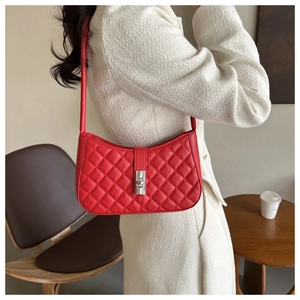 Vue détaillée du sac baguette en similicuir rouge matelassé avec fermoir rotatif argenté