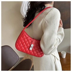 Détail d'un sac à main en cuir matelassé rouge avec fermoir rotatif en métal argenté