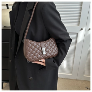 Détail d'un sac hobo matelassé en cuir PU marron foncé avec un fermoir rotatif argenté