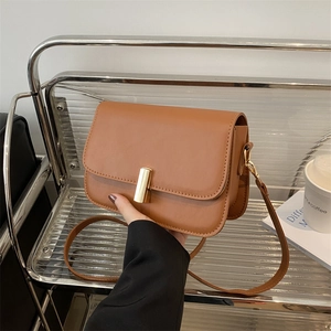 Sac bandoulière en cuir marron avec fermoir doré cylindrique vu de dessus en détail