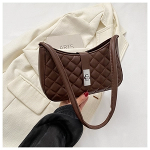 Détail du sac sous l'aisselle marron foncé avec fermoir rotatif argenté et motif matelassé