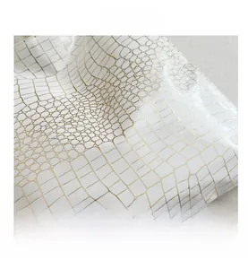 Detailed close-up of high-quality faux crocodile leather texture in pearl white and gold