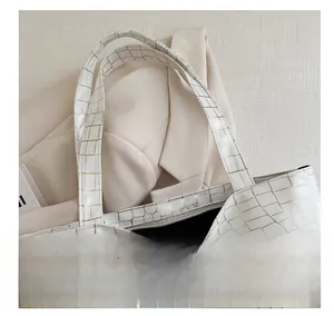Detail of high-quality white crocodile pattern tote bag with golden embossed texture