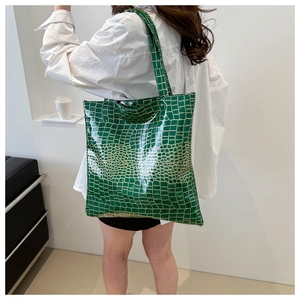 Bright green crocodile pattern tote bag shown on model to demonstrate large capacity size