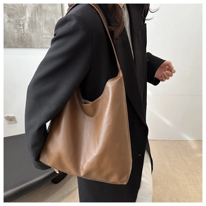Brown large leather hobo bag shown on model highlighting the spacious commute design