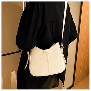Detail of a beige PU leather crossbody bag with vertical stitching and Fashion label
