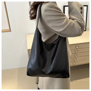Side view of large black leather hobo tote bag showing material texture and drape