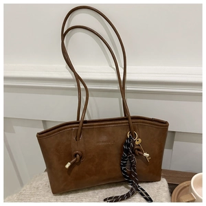 Detail of coffee brown faux leather tote with knotted straps and vintage texture