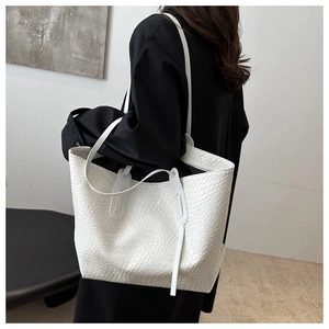 Detail view of large white woven tote bag featuring a textured PU leather finish