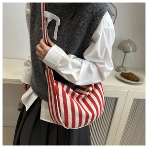Detail of red and white striped canvas hobo bag showing texture and crescent shape