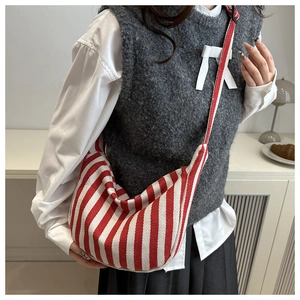 Classic red and white striped hobo canvas crossbody bag shown on a model in a casual outfit
