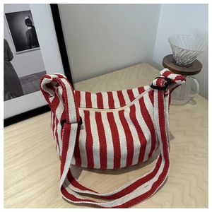 Detail of red and white striped canvas tote with zipper closure and adjustable strap
